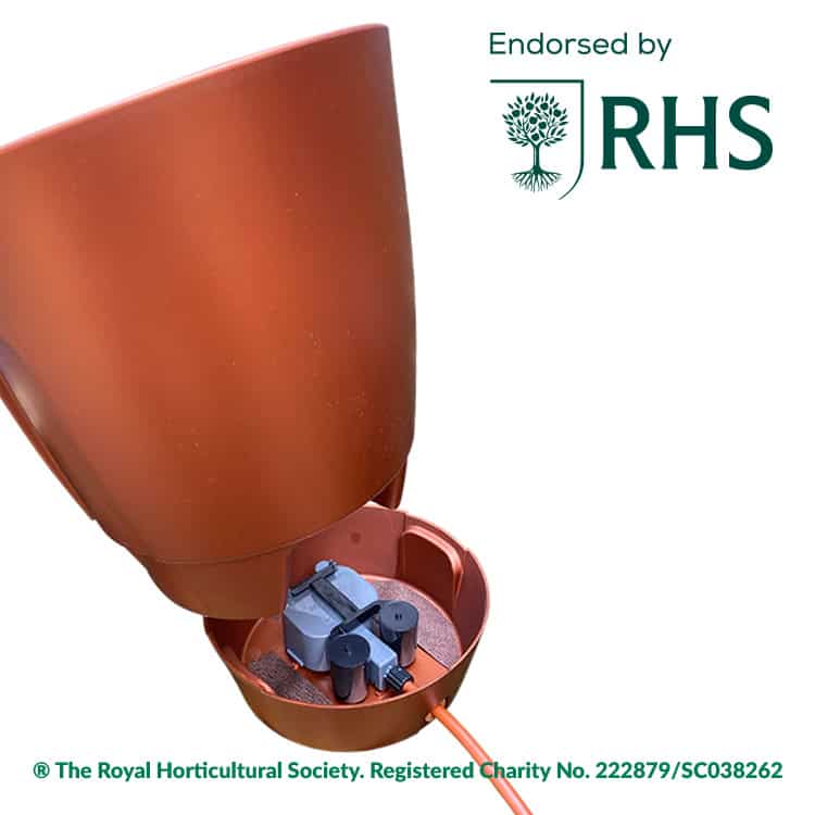 Orange garden irrigation device inside a pot, with an 'Endorsed by RHS' logo in the top-right corner.