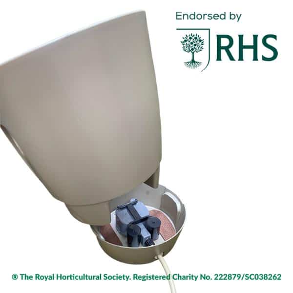 Beige garden gadget with its lid open, showing an internal circular chamber and components, RHS endorsement logo visible in the corner.